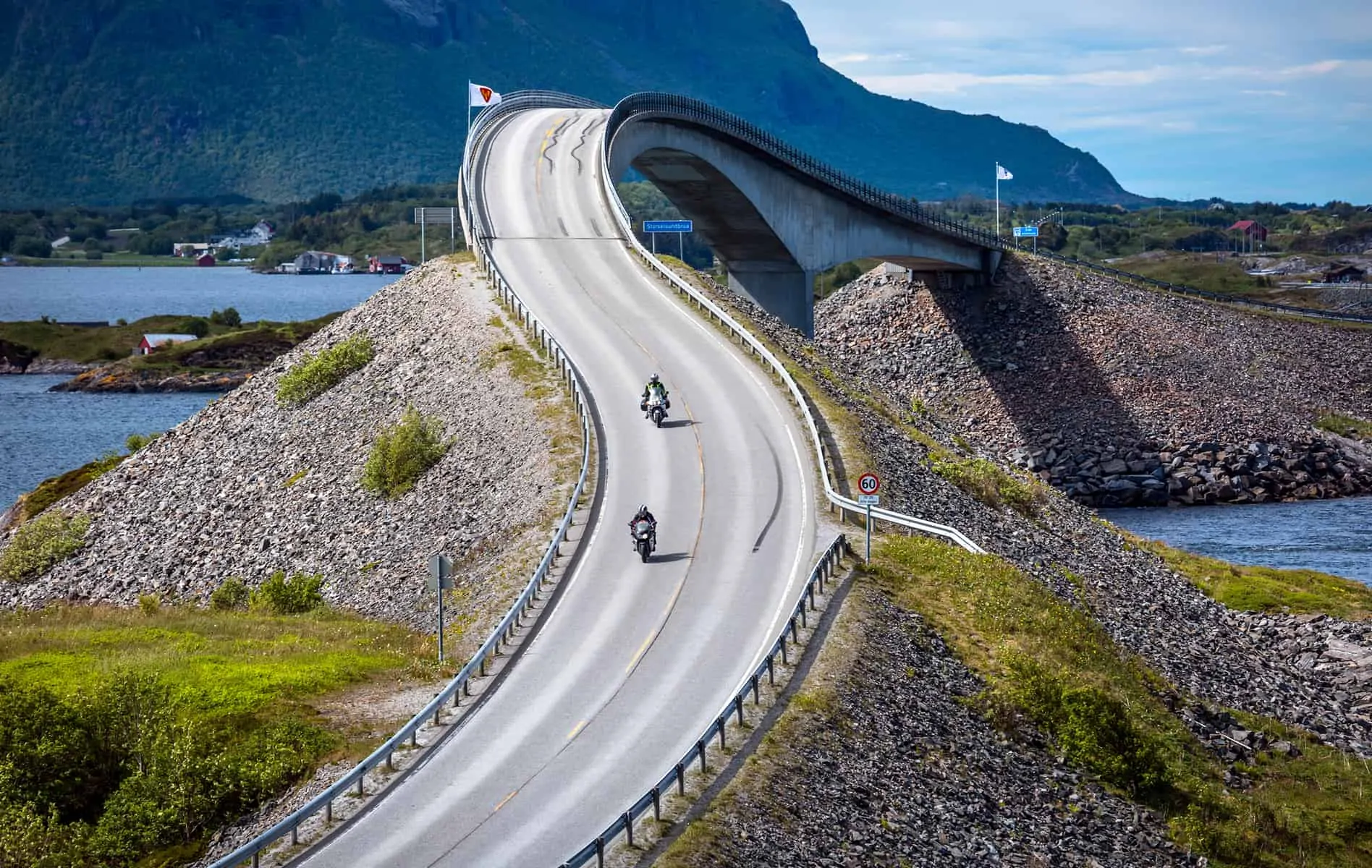 Two bikers on motorcycles. Atlantic Ocean Road or the Atlantic Road (Atlanterhavsveien) been awarded the title as "Norwegian Construction of the Century".