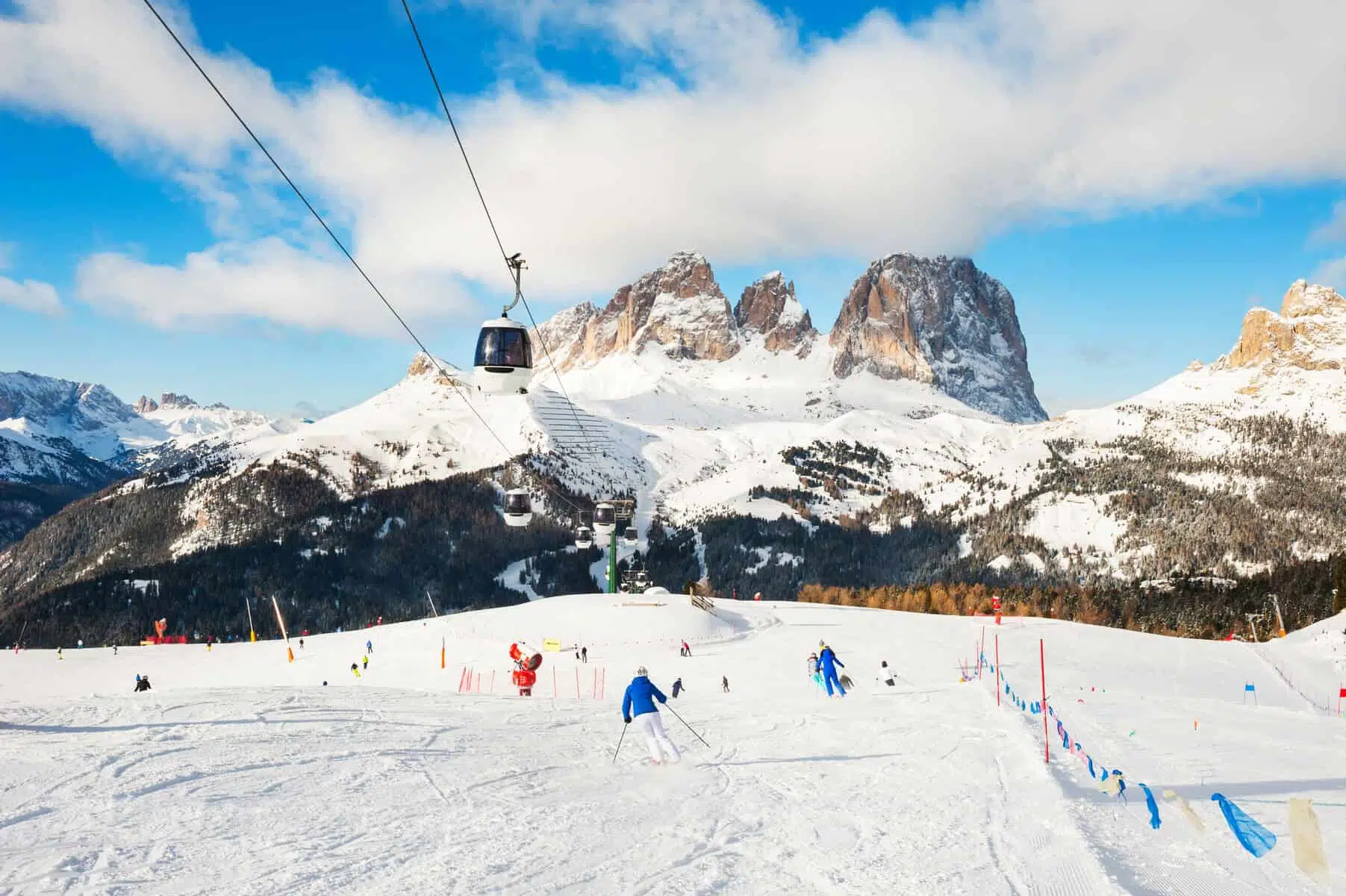 Canazei og verdens største liftkort, Super Dolomiti 3 Skiers riding on the ski slope in winter Dolomites, Italy