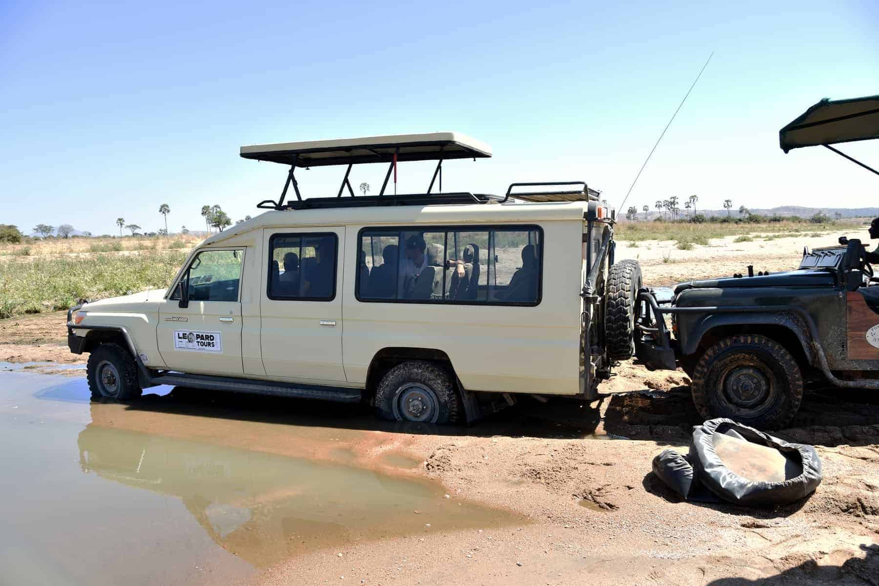 Ruaha National Park, Tanzania, Africa - August 6 2018: a safari car is stuck in the river while another car is trying to push it out, Ruaha National park, Tanzania.