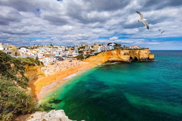Ferie på Algarve kysten, "rigeligt med sol" 10 View of Carvoeiro fishing village with beautiful beach, Algarve, Portugal. View of beach in Carvoeiro town with colorful houses on coast of Portugal. The village Carvoeiro in the Algarve Portugal.