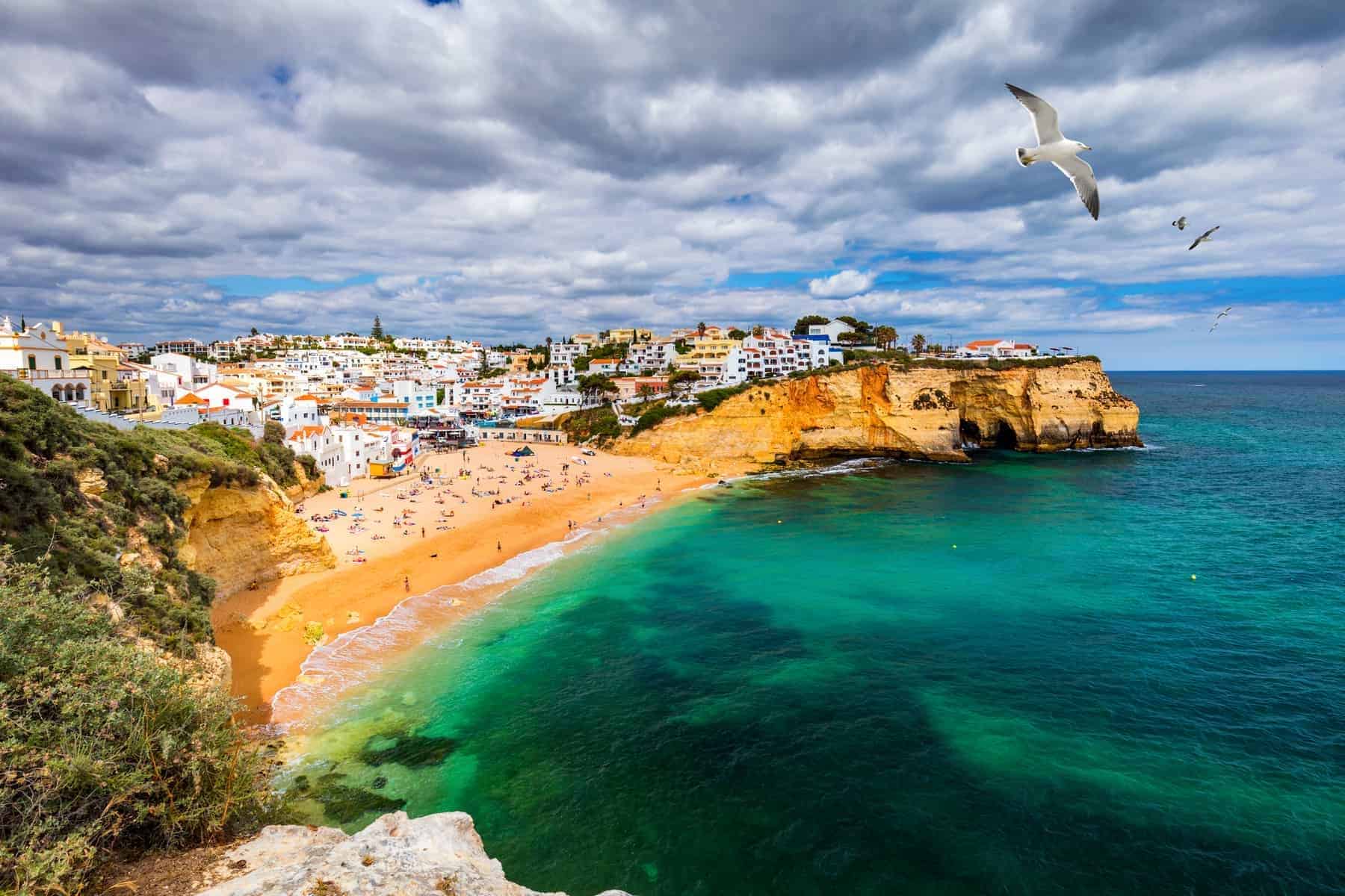 View of Carvoeiro fishing village with beautiful beach, Algarve, Portugal. View of beach in Carvoeiro town with colorful houses on coast of Portugal. The village Carvoeiro in the Algarve Portugal.