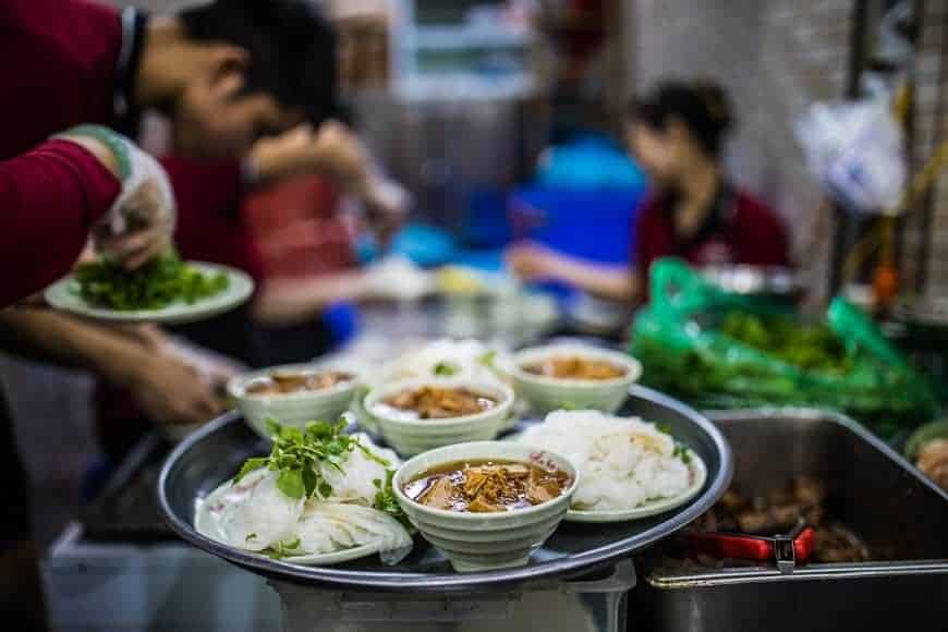 Gadekøkken i Hanoi med gæster på lave plastikstole