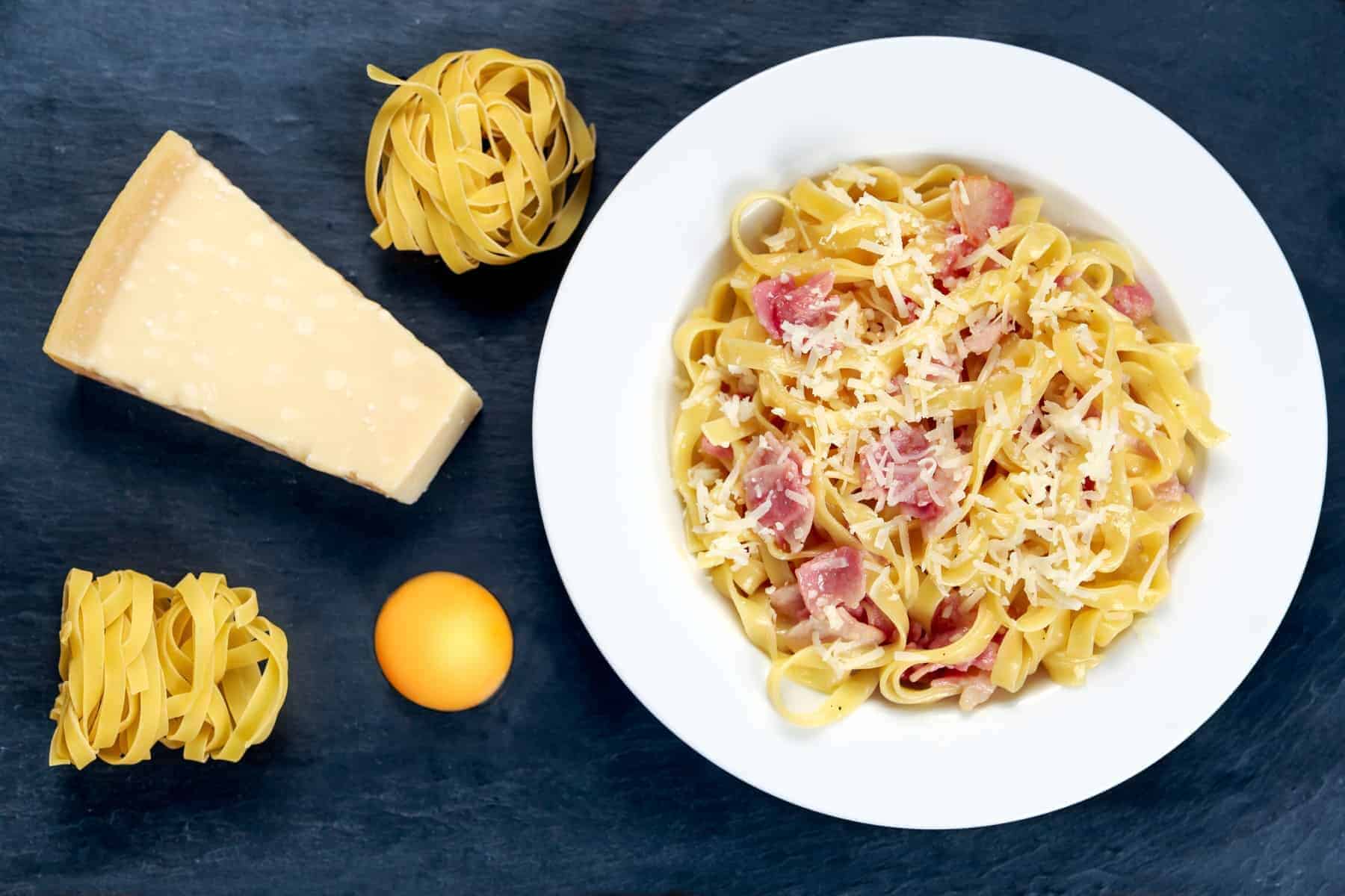 Classic Pasta carbonara Italian. decorated with tagliatelle pasta æg , og Parmesan Cheese on blue background