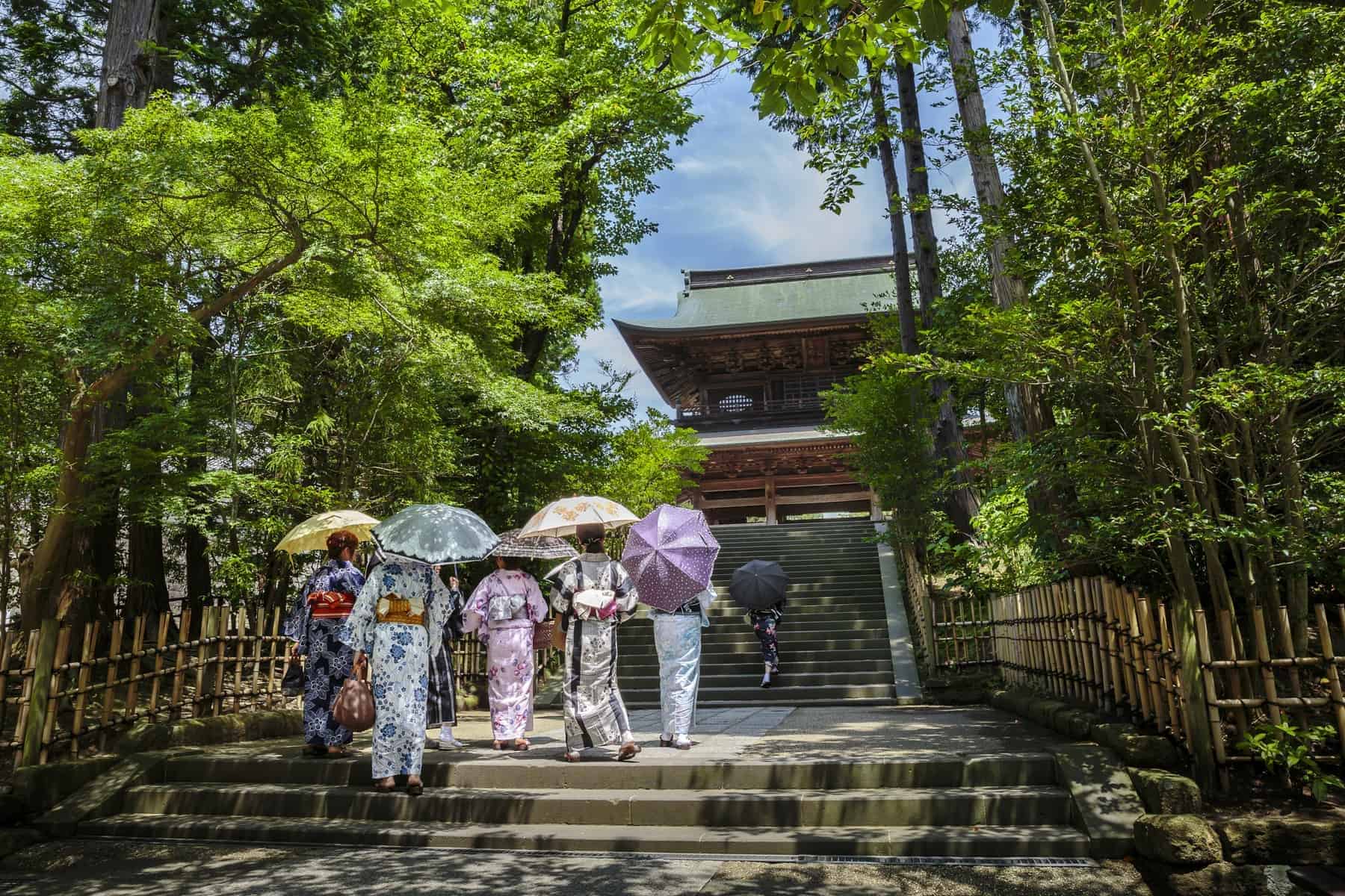 Kvinder i traditionelle kimonoer foran et tempel i Kamakura, Kanagawa præfektur, Japan.