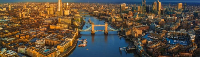 London, England - Panoramic aerial skyline view of London including iconic Tower Bridge with red double-decker bus