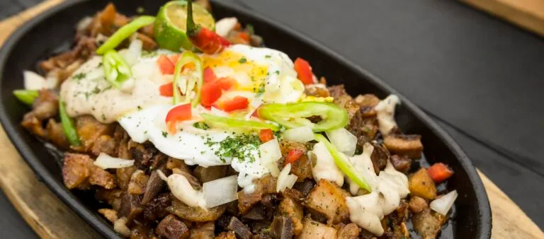 Filippinsk mad er et lækkert og historisk fusionskøkken 7 Freshly cooked Pork Sisig with egg, onions and chilies. A popular Filipino dish.
