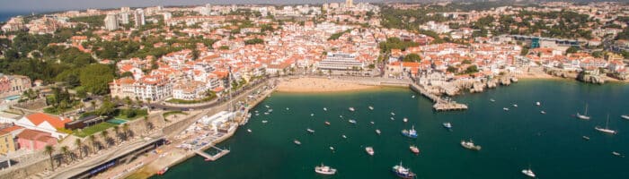 Cascais Portugal aerial view of yachts, beach, bars and town. Nordens store rejseportal. 