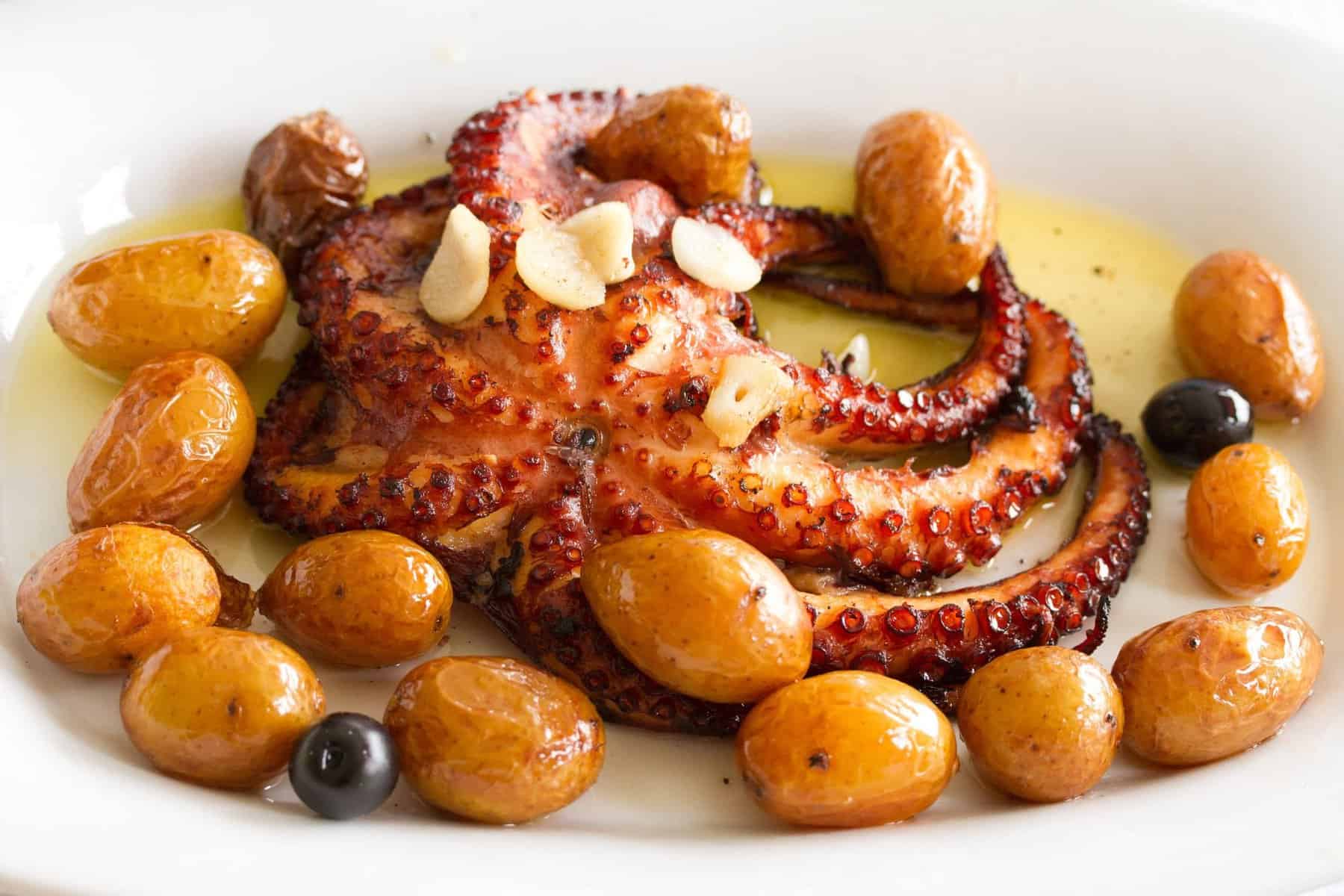 Traditional portuguese dish octopus with potato on white plate