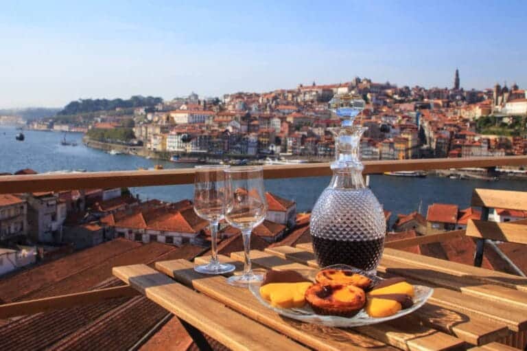 Portugisisk mad: En introduktion til det rige og varierede køkken 14 Portugal og lækker mad, Table with view a wonderful view over the river in Porto, Portugal.