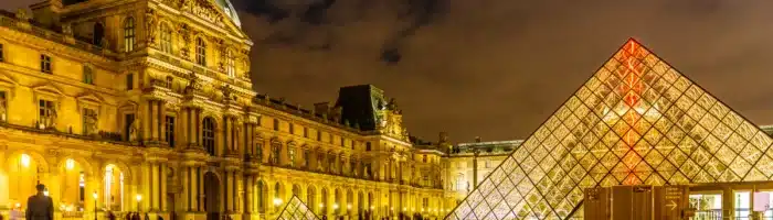Richelieu wing and the glass pyramid at the Louvre museum at night in Paris, in Ile de France, France