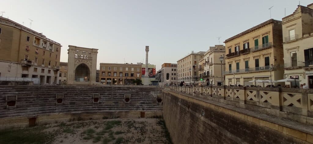 Det romerske amfiteater i udgravningen midt på Piazza Sant Oronzo i Lecce med Sant Oronzo-søjlen bagved