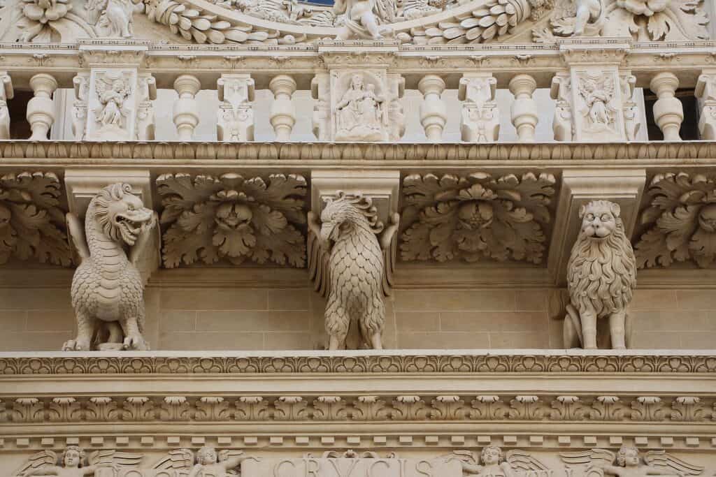 Udskårne dyr, engle og balustre i pietra leccese på facaden af Basilica di Santa Croce i Lecce