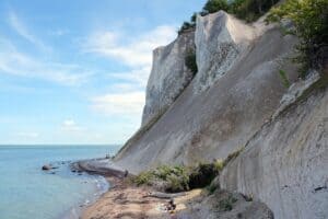 Møns Klint (moens klint) rejser sig hvidt over stranden ved Østersøen
