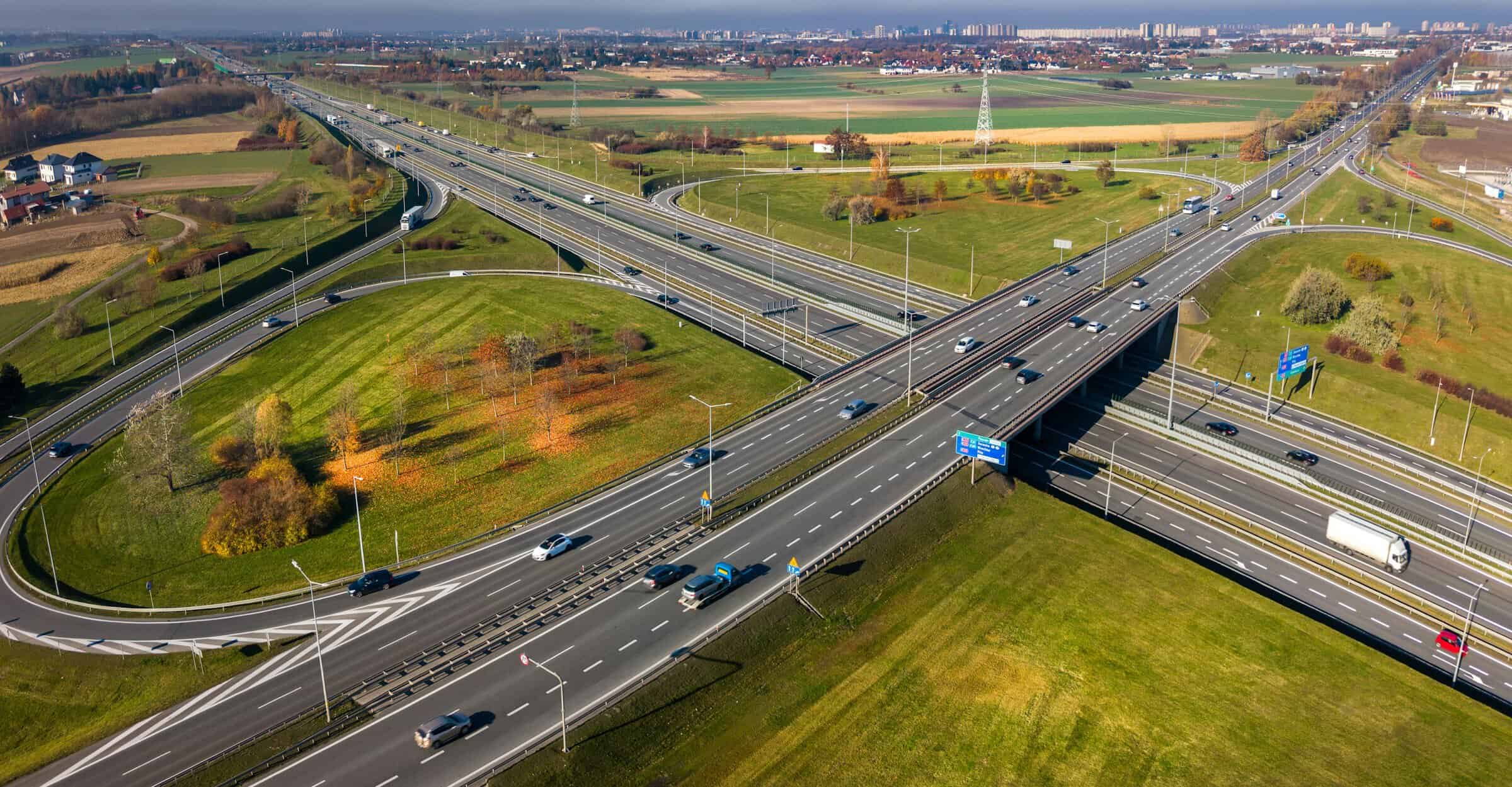 Motorvejskryds omgivet af efterårsfarvet landskab i Polen, set fra luften. Foto: Unsplash / Jakub Żerdzicki.
