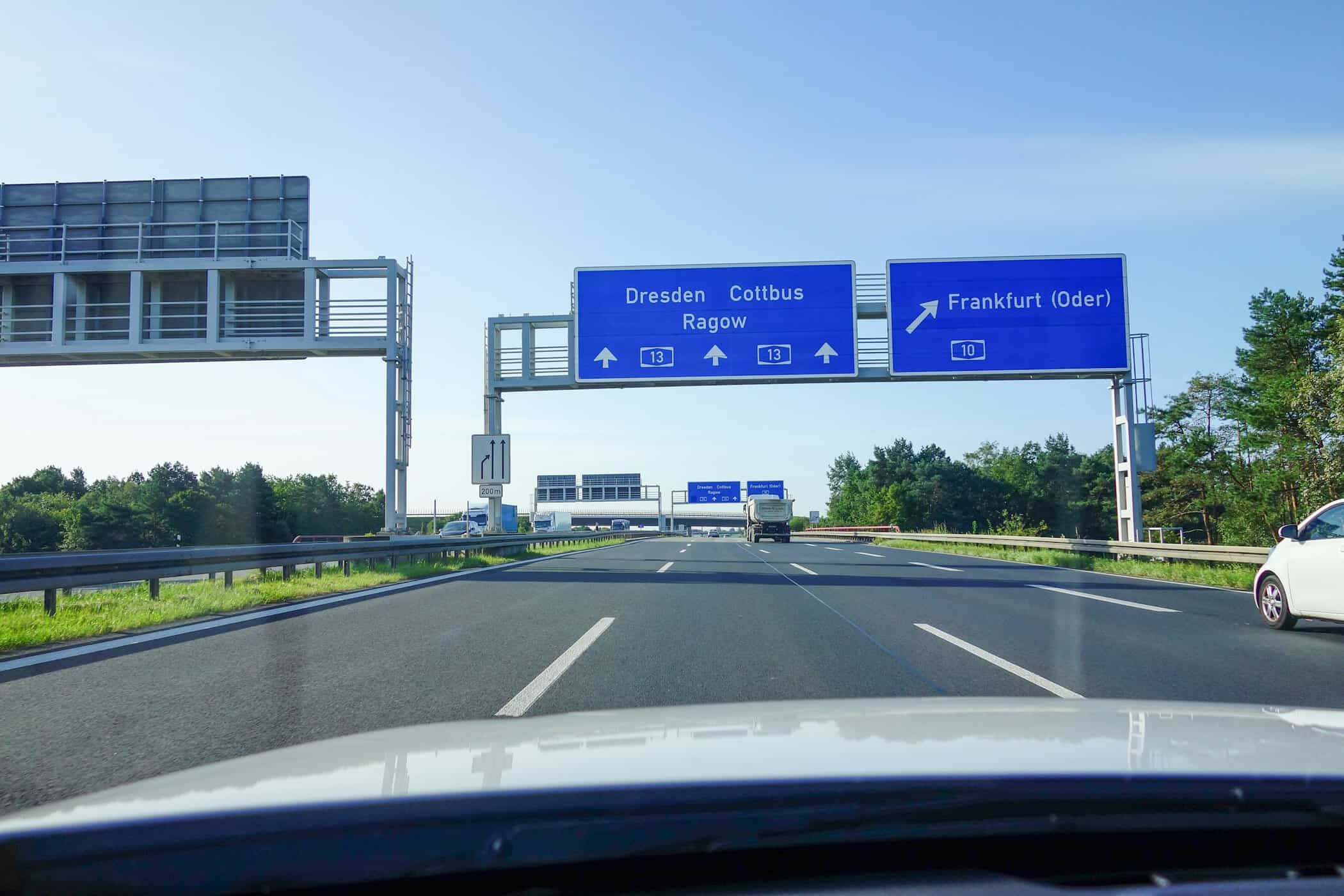 Blå motorvejsskilte peger mod Dresden, Cottbus og Frankfurt på en tysk Autobahn. Foto: Unsplash / Zion C.