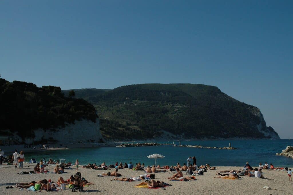 Monte Conero set fra stranden ved Sirolo med badegaester i forgrunden