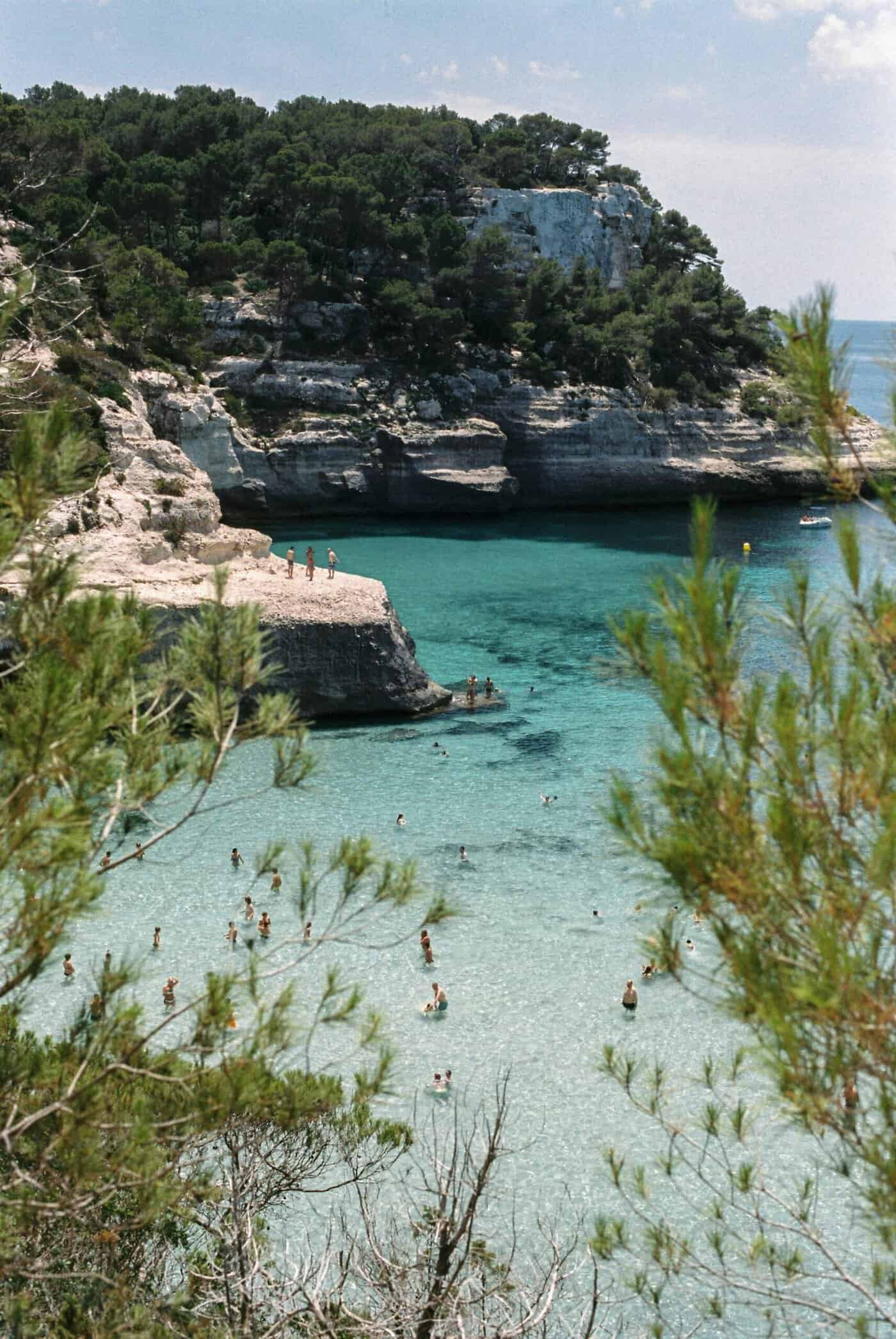 Swimmers and cliff jumpers at a beach in Menorca (Spain) Unsplash